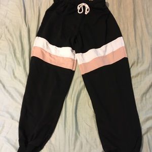 Black sweatpants with pink and white stripes
